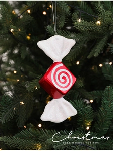 Close-up of red and white striped candy ornaments with glitter on a Christmas tree