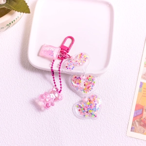 Pink acrylic candy bear keychain with star sequins inside transparent heart pendants