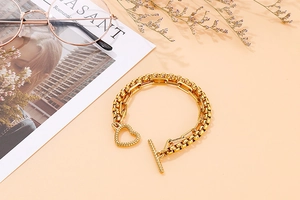 Dettaglio del bracciale a doppio strato in acciaio inossidabile dorato con ciondolo a cuore