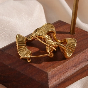 Chic irregular wavy gold earrings in 18K gold plated stainless steel on wooden stand