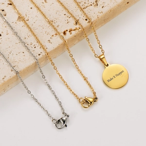 Detail of gold and silver stainless steel necklaces featuring Make It Happen engraving