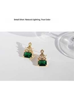 Detail view of emerald cut green gemstone earrings with sparkling crystal accents