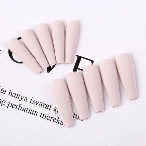 Detail view of matte nude pink long coffin press-on nails in a ballet shape