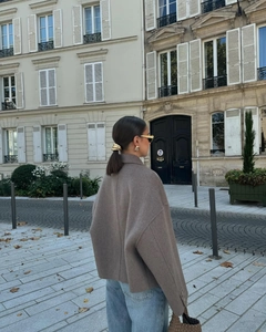Street view of a woman in a brown wool coat with a relaxed fit and back detail