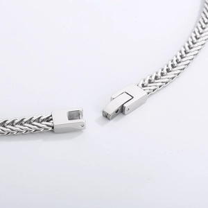 Detailed close-up of a silver stainless steel curb chain with a secure open metal clasp