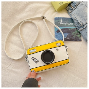Detail of yellow and white camera shaped crossbody bag with metallic silver buckle