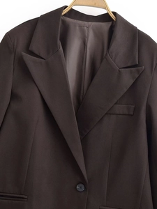 Detailansicht von dunkelbraunem Blazer-Stoff, fallendem Revers und einreihigem Knopf