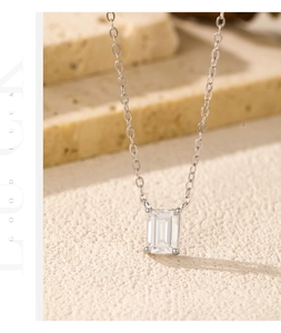 Detailed view of emerald-cut moissanite pendant with four-prong setting on silver chain