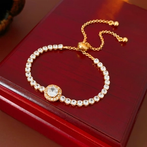 Macro d'un bracelet ajustable en or et zircon présenté sur un coffret cadeau en bois rouge
