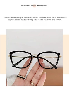 Close-up of black cat-eye glasses with golden metal temples and clear protective lenses
