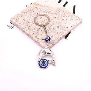 Ethnic vintage silver dolphin keychain featuring decorative blue evil eye resin beads