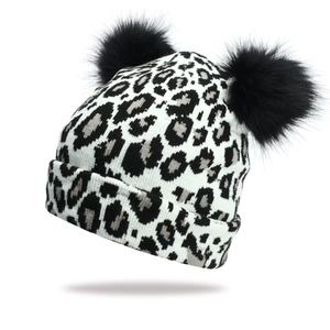 Leopard print knitted beanie for women featuring two fluffy faux fur pom poms in winter