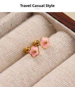 Macro detail of pink flower stud earrings with gold trim and screw back fasteners