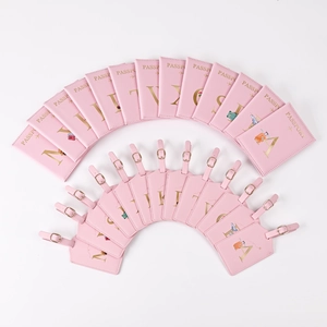 Pink passport cover and luggage tag set with gold letters and travel illustrations