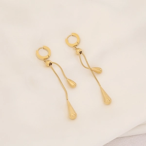 Detail of golden tassel drop earrings with sleek chain and waterdrop charms