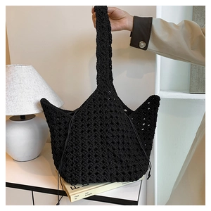 Dettaglio ravvicinato di una borsa all'uncinetto nera con motivo a rombi e coulisse di chiusura