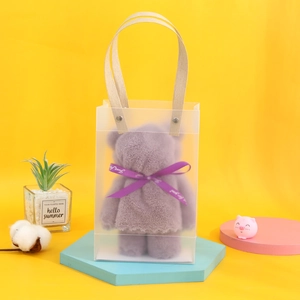 Detail of purple bear-shaped towel in PVC gift bag with stylish wooden handle
