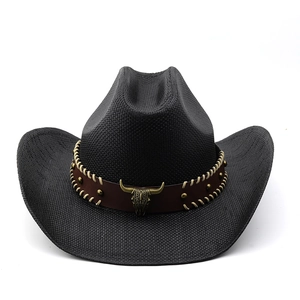 Detail of black woven cowboy hat featuring a leather band with bull head emblem buckle