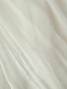 Close-up of soft white vertical pleated fabric texture for elegant summer dress
