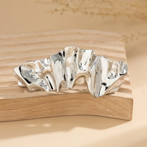 Detail showing irregular liquid metal texture and silver chrome finish on hair clip
