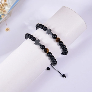 Close-up of 8mm matte black beads bracelet with tiger eye stone and metal cross charm