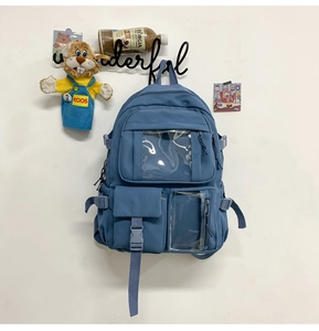 Dettaglio dello zaino in nylon blu con tasche multiple e scomparti in PVC trasparente