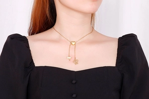 Collier en Y doré avec cœur et pendentifs libellule et papillon porté par un mannequin