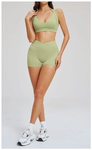 Dettaglio del set yoga verde chiaro con pantaloncini a vita incrociata e reggiseno halter