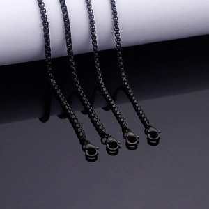Four black stainless steel box chain necklaces with lobster clasps on reflective surface