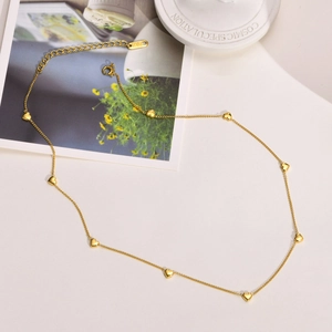 Detailed close-up of a 18K gold plated necklace featuring multiple mini heart pendants