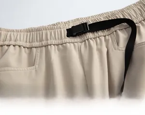 Dettaglio della vita elastica regolabile con fibbia in plastica nera sui pantaloni