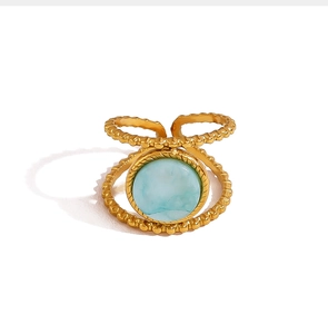 Detail eines goldenen Rings mit Amazonit-Stein und Perlenstruktur am Metallband