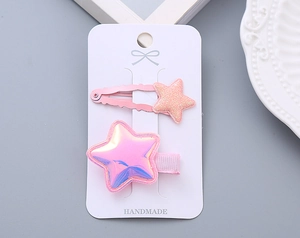 Pair of pink glitter and reflective star hair clips for girls on handmade display card