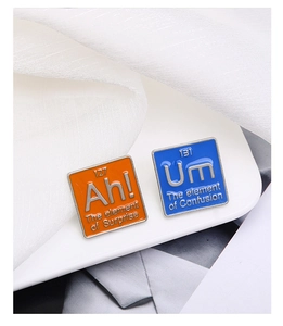 Détail des broches en émail colorées avec les éléments du tableau périodique Ah et Um