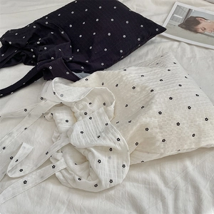 Détail de sacs fourre-tout en mousseline noir et blanc avec motif floral minimaliste