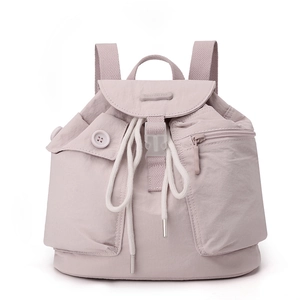 Detail of light purple nylon backpack showing front buckle and drawstring closure texture