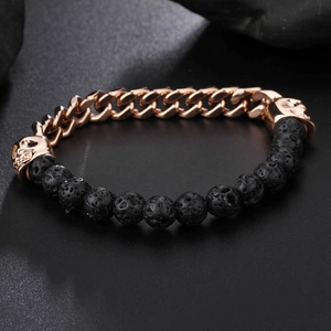 Close-up of rose gold skull charms and black lava stone beads on a vintage bracelet