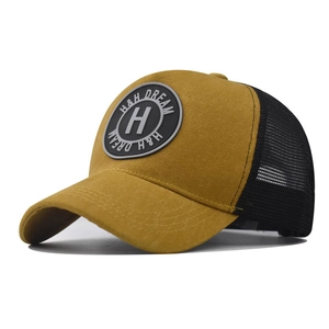 Close-up of mustard cotton baseball cap with H embroidery and breathable black mesh back