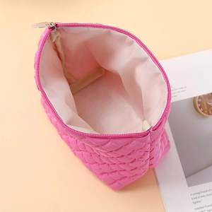 Detail view of pink quilted makeup bag interior showing spacious white lining and zipper