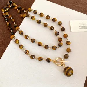 Collana vintage di perle occhio di tigre con chiusura OT dorata e pendente tondo