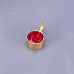 Detailed close-up of a red round rhinestone pendant with gold-plated stainless steel base