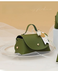 Close-up of green leather wedding gift box with gold studs and elegant white ribbon