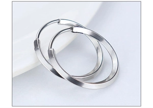Macro shot of silver titanium steel hoop earrings with high polish finish and rhombic edge