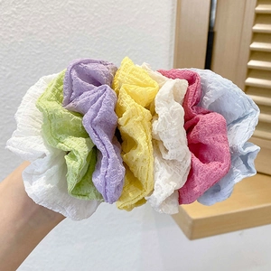 Detail of multi-color bubble fabric scrunchies showing textured material and soft pastel tones
