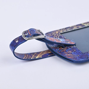 Detailed macro view of blue PU leather luggage tag with gold patterns and silver buckle