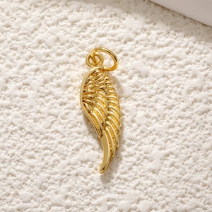 Vue macro d'un pendentif aile plaqué or avec texture détaillée sur fond texturé