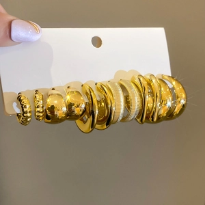 Close-up of assorted gold textured hoop earrings set featuring ribbed and polished designs