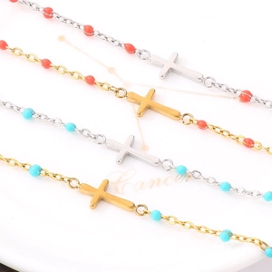 Close-up of beaded titanium steel bracelets with colorful charms and cross pendants