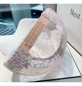 Detail shot of a pink sequin baseball cap showing the adjustable snap closure on back
