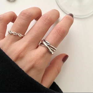 Detail of 925 sterling silver woven link and triple band cross rings on a model hand